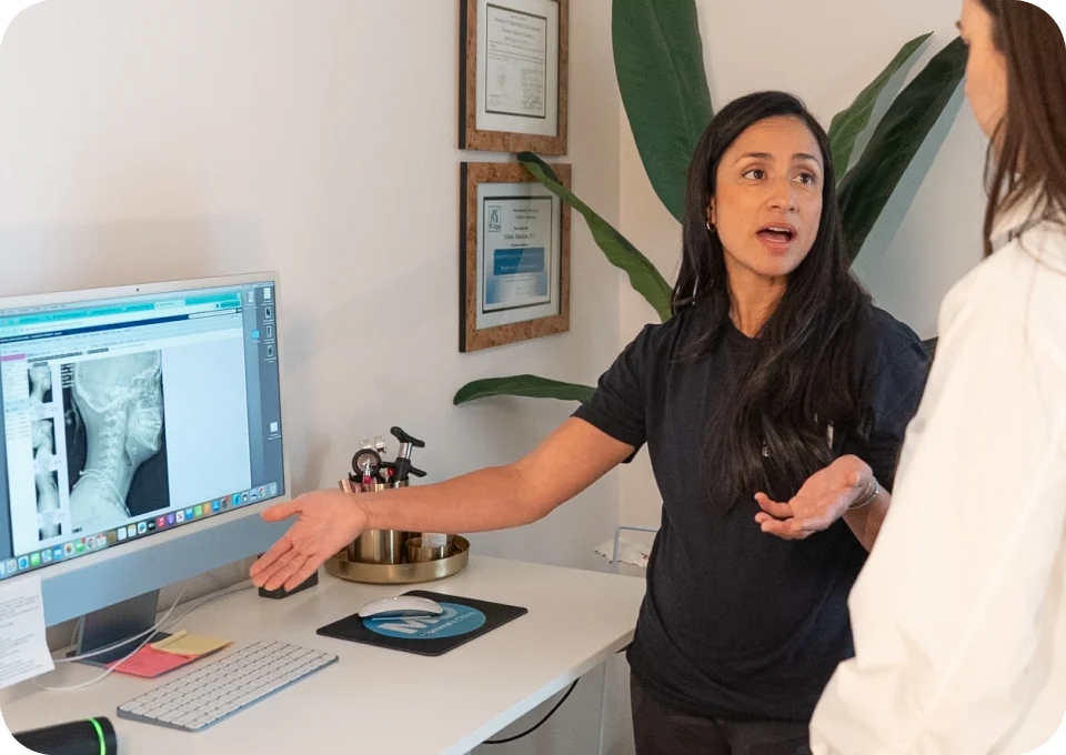 Dr. Aimee VanDerschelden, DC explaining a spinal X-ray to a patient at Momma's Chiro