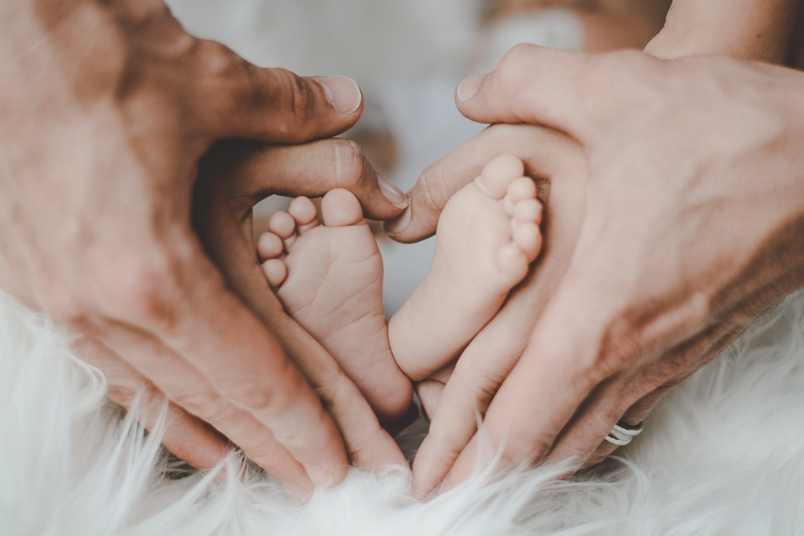 person-holding-baby-s-feet-2456327-scaled
