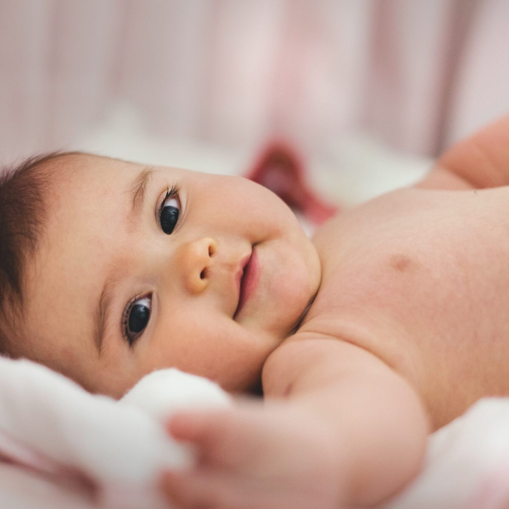 baby-lying-on-pink-bed-1556706-scaled